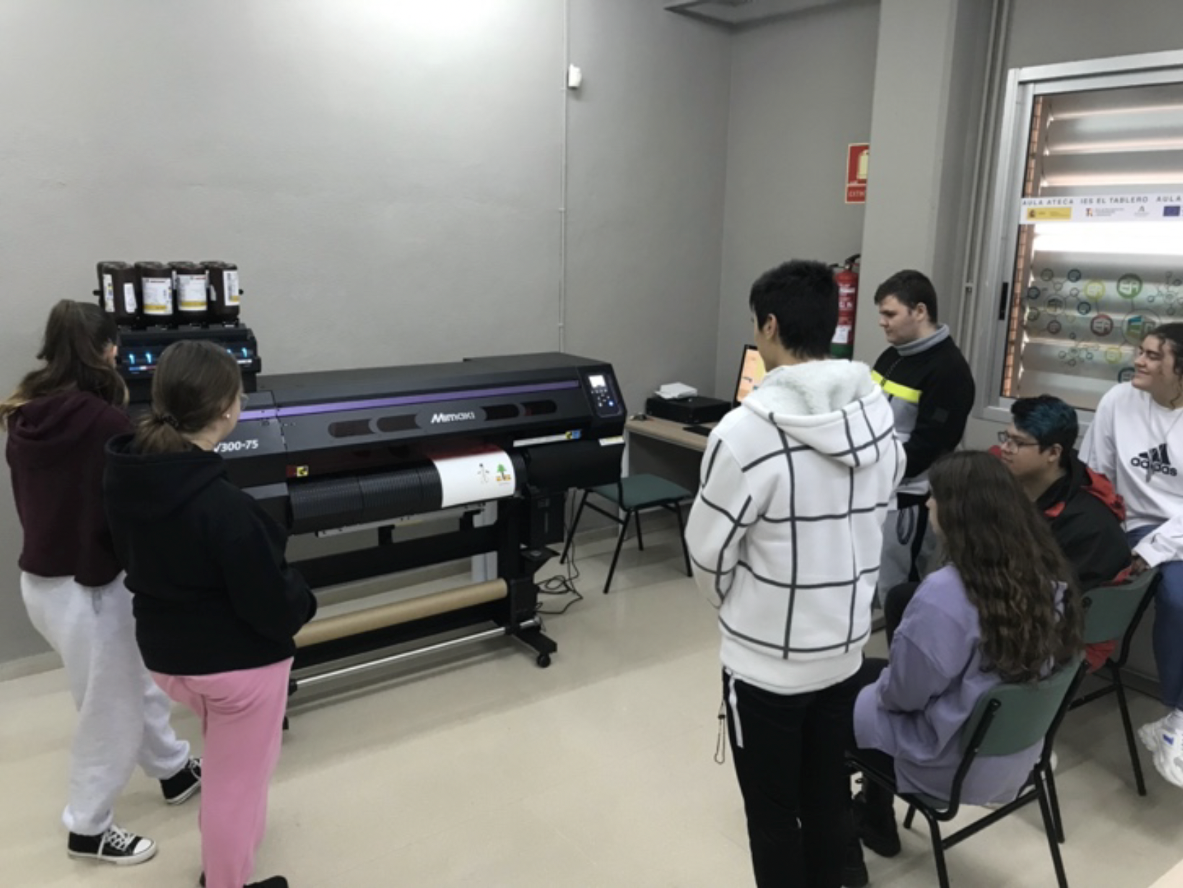 Estudiantes observando impresora Mimaki